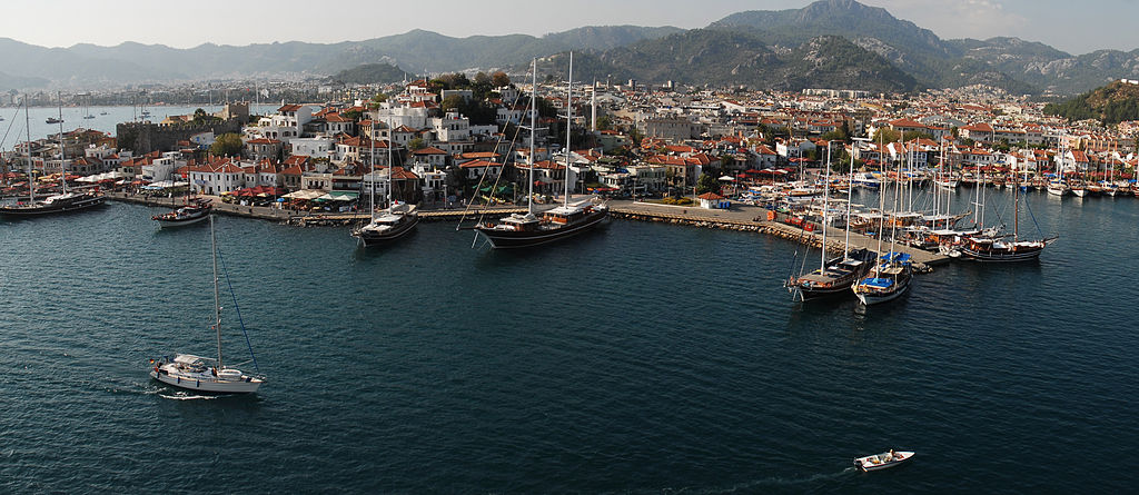 Aerial view of Turkey&#039;s Marmaris Harbor filled with boats of all kinds with the village and mountains in the backdrop