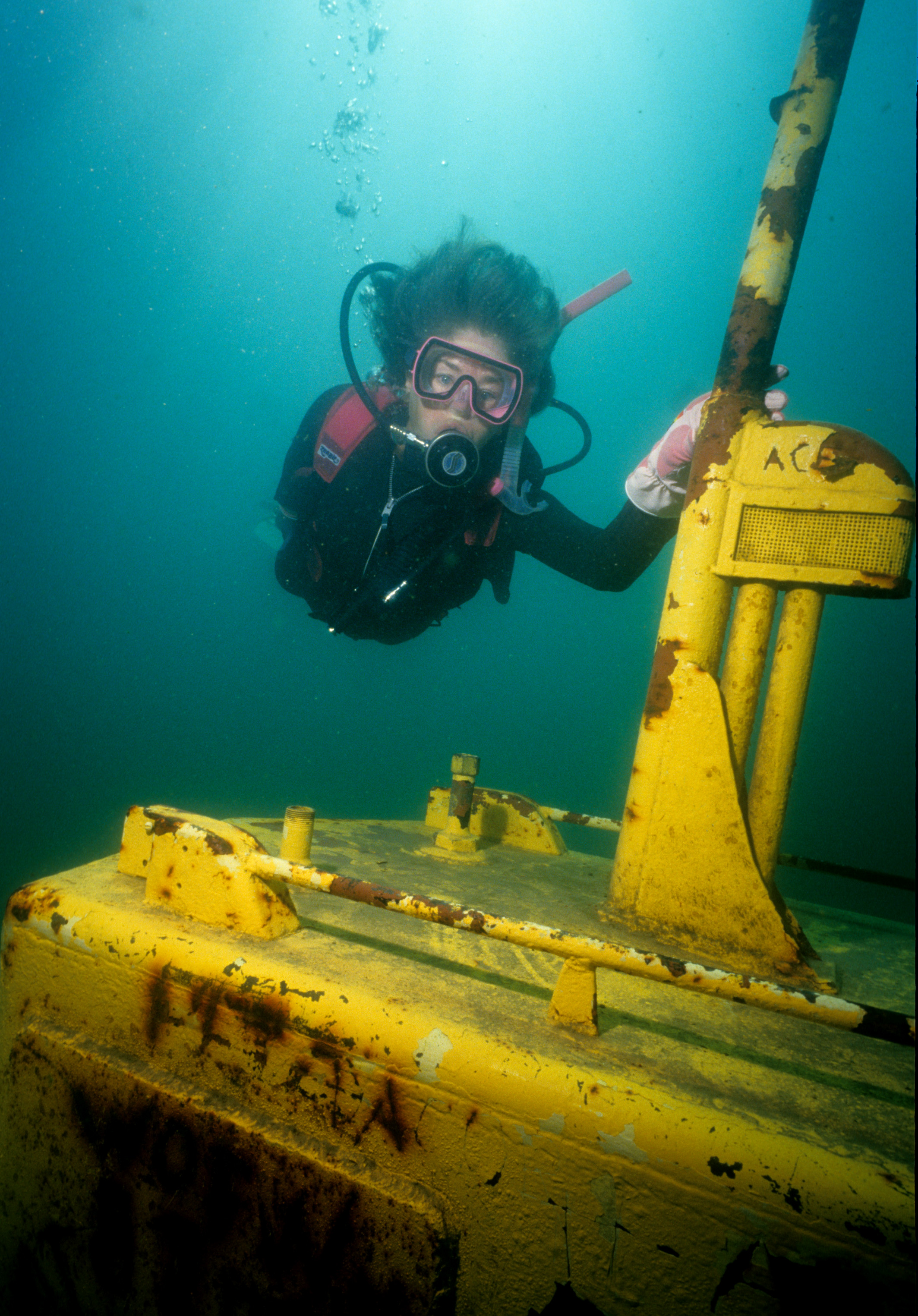 Female diver explores a thirty-three foot long yellow submarine at Pearl Lake in Illinois